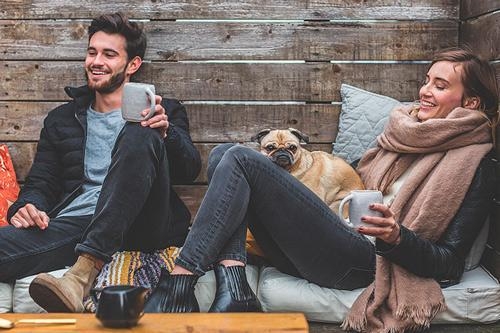 man en vrouw relaxen in de tuin met koffie